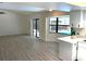 Open-concept living area with new floors, big windows, sliding glass doors, and views of the pool at 8546 Amber Oak Dr, Orlando, FL 32817