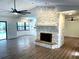 Open living area with a stone fireplace, new flooring, and a kitchen in the background at 8546 Amber Oak Dr, Orlando, FL 32817