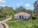 Expansive lawn and manicured landscaping surround this charming single-story home with a tile roof at 8585 Cypress Ridge Ct, Sanford, FL 32771