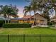 Landscaped backyard features a lush lawn, a screened-in porch, a fire pit, and privacy hedges, creating a serene outdoor space at 8585 Cypress Ridge Ct, Sanford, FL 32771