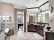 Elegant bathroom featuring a soaking tub with marble accents and a dark wood vanity with a black marble countertop at 8585 Cypress Ridge Ct, Sanford, FL 32771