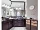 Upscale bathroom featuring a large mirror over a dual vanity with dark wood cabinets and granite countertops at 8585 Cypress Ridge Ct, Sanford, FL 32771