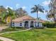 Beautifully landscaped home featuring palm trees, a manicured lawn, and a tile roof, offering luxurious curb appeal at 8585 Cypress Ridge Ct, Sanford, FL 32771