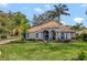 Elegant home featuring lush landscaping, mature palm trees, a water feature, and tile roof in a manicured lawn at 8585 Cypress Ridge Ct, Sanford, FL 32771