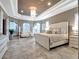 Elegant main bedroom features tray ceilings, a crystal chandelier, and a sitting area with bright, natural light at 8585 Cypress Ridge Ct, Sanford, FL 32771