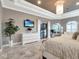 Luxury main bedroom featuring a private lanai, a built-in TV, and an elegant dresser with decorative floral arrangement at 8585 Cypress Ridge Ct, Sanford, FL 32771