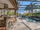 Covered outdoor kitchen with built-in grill and bar seating overlooking the pool and patio at 8585 Cypress Ridge Ct, Sanford, FL 32771