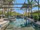 Screened-in pool with a built-in spa and rock waterfall feature, surrounded by lush landscaping at 8585 Cypress Ridge Ct, Sanford, FL 32771