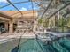 Screened outdoor pool with a hot tub, covered kitchen with bar seating and outdoor dining area, all perfect for entertaining at 8585 Cypress Ridge Ct, Sanford, FL 32771