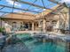 This outdoor space offers a screened pool and spa, bar, and comfortable seating for relaxing and entertaining at 8585 Cypress Ridge Ct, Sanford, FL 32771