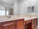 Bathroom featuring double vanity, large mirror, tiled shower, and neutral color scheme at 16315 Bristol Lake Cir, Orlando, FL 32828