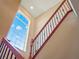 Staircase with dark iron railings and wooden handrail, illuminated by a large window at 16315 Bristol Lake Cir, Orlando, FL 32828