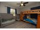 Bright bedroom with a ceiling fan, two cribs, and a wooden bunk bed at 1659 Nantucket St, Deltona, FL 32725