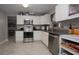 Well-lit kitchen featuring stainless steel appliances, granite countertops, and white cabinets at 1659 Nantucket St, Deltona, FL 32725