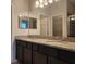 Bathroom featuring a double sink vanity with granite countertop, large mirror, and dark wood cabinets at 1820 Shumard Ave, St Cloud, FL 34771