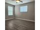 Bright bedroom with wood-look flooring, two windows, and neutral wall color at 1820 Shumard Ave, St Cloud, FL 34771