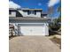 Exterior of home featuring a two-car garage and a brick-paved driveway, with landscaping and a light blue facade at 1820 Shumard Ave, St Cloud, FL 34771