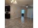 Spacious open-plan living room with tiled floors, ceiling fan, and access to the kitchen area at 1820 Shumard Ave, St Cloud, FL 34771