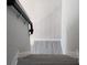 View looking down the staircase, which has a dark banister and modern gray flooring at 1820 Shumard Ave, St Cloud, FL 34771