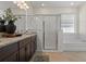 Bright bathroom featuring a large vanity with granite countertop, shower, and soaking tub at 1942 Rankin St, Kissimmee, FL 34744