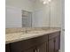 Bathroom featuring double vanity with dark cabinets, granite countertops and decorative lights at 1942 Rankin St, Kissimmee, FL 34744