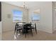 Bright dining area with a modern round table set, neutral paint, and bright sunlight streaming through large windows at 1942 Rankin St, Kissimmee, FL 34744