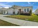 Beige single-story home featuring a two-car garage, well-manicured lawn, and stone accents at 1942 Rankin St, Kissimmee, FL 34744