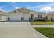 Beige single-story home featuring a two-car garage, well-manicured lawn, and stone accents at 1942 Rankin St, Kissimmee, FL 34744