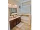 Bathroom featuring a double vanity, soaking tub, and separate glass-enclosed shower at 2401 Begonia St, Mascotte, FL 34753