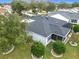 Aerial view of backyard with screened patio, lush landscaping, and well-maintained lawn at 2488 Cherokee Ct, The Villages, FL 32162