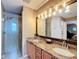 Bathroom featuring a glass shower and granite double sink vanity at 2488 Cherokee Ct, The Villages, FL 32162