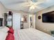 Bedroom with a fan, an open door to another room, and a TV on the wall at 2488 Cherokee Ct, The Villages, FL 32162