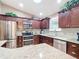 Modern kitchen featuring stainless steel appliances and dark wood cabinetry at 2488 Cherokee Ct, The Villages, FL 32162