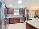 Well-lit kitchen with stainless steel appliances, dark wood cabinets, and tile floors at 2488 Cherokee Ct, The Villages, FL 32162