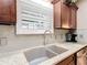 Close-up of kitchen sink with granite countertop and white subway tile backsplash at 2488 Cherokee Ct, The Villages, FL 32162