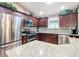 Modern kitchen featuring stainless steel appliances and dark wood cabinetry with greenery at 2488 Cherokee Ct, The Villages, FL 32162