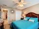 Comfortable main bedroom with wood floors, fan, and a view to another room at 2488 Cherokee Ct, The Villages, FL 32162