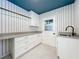 Modern laundry room features white cabinets, gray countertop, and black hardware fixtures at 2520 Chanute Trl, Maitland, FL 32751