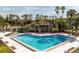 Community pool surrounded by a pool house, palm trees and lounge chairs creating a relaxing environment at 285 Scottsdale Sq # 285, Winter Park, FL 32792