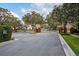 View of gated entrance of community framed by mature trees and manicured landscaping at 329 Streamview Way, Winter Springs, FL 32708