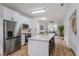 Modern kitchen featuring white cabinets, stainless steel appliances, and an island with seating at 329 Streamview Way, Winter Springs, FL 32708