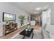 Open-concept living room featuring light wood floors, a stylish console, and view into the kitchen at 329 Streamview Way, Winter Springs, FL 32708