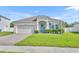 Beautiful home with a brick paver driveway, lush lawn, and blue door and shutters at 3563 Fernanda Dr, Deltona, FL 32738