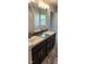 Elegant Primary bathroom with dual sinks, granite countertop, and large mirror at 411 Caribbean Ct, Kissimmee, FL 34759