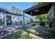 Backyard view of covered patio, outdoor seating, fire pit, BBQ grill, and lush greenery, perfect for entertaining at 441 Spoonbill Ct, Kenansville, FL 34739