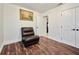 Cozy bedroom featuring wood floors, a brown leather chair, and an elegant landscape painting at 441 Spoonbill Ct, Kenansville, FL 34739