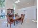 Sunlit dining room with tall windows, china cabinet, and marble floors at 441 Spoonbill Ct, Kenansville, FL 34739