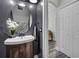 Stylish half-bathroom featuring a modern sink, dark gray walls and hardwood floors at 4941 Casa Vista Dr, Orlando, FL 32837