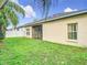 Home's backyard shows well-kept lawn and screened in lanai, framed by a wooden fence at 4981 Waterside Pointe Cir, Orlando, FL 32829