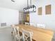 Dining area with modern light fixture and light wood floors that lead into the living room at 4981 Waterside Pointe Cir, Orlando, FL 32829